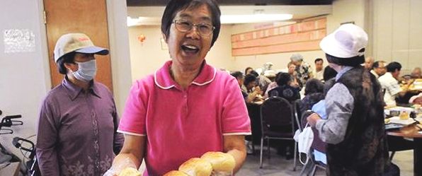 Lucia Miao, 64, a longtime employee of Jene Wah Inc., serves lunch to seniors.